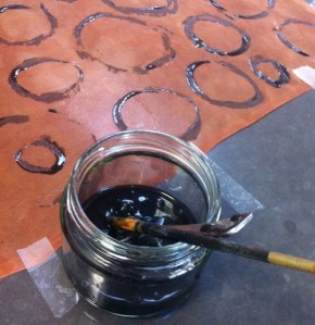 Silk dyed with avocado pips taped to flat surface and painted with darkened avocado skin dye paste.