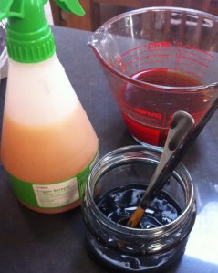 Avocado skin thickened solution in the measuring jug, old iron water in the spray bottle and darkened paste in the foreground jar.