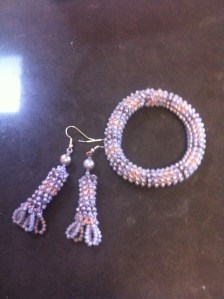 Ugly variegated pink/blue/brown cotton embroidery thread crocheted with plate blue beads into a stretchy bracelet requiring no closure and a pair of earrings with loop finishes.